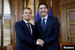 PM Kanada Justin Trudeau (kanan) berjabat tangan dengan Presiden Perancis Emmanuel Macron di Ottawa, Ontario, Kanada, 6 Juni 2018. (Foto: dok).