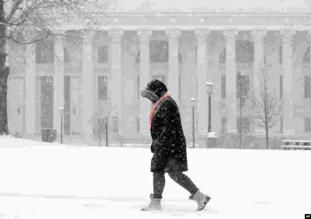 一位行人在纽约州府奥尔巴尼的雪中步行。美国东北部经历了记录上最温和的冬天之一，但初春的这股冷锋给这一地区带来降雪及阵风。