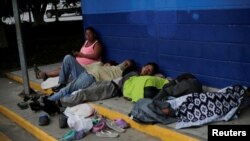 Hondureños duermen en el suelo en el puesto de control del cruce fronterizo de Corinto entre Guatemala y Honduras mientras intentan llegar a una caravana de migrantes hacia Estados Unidos, en Omoa, Honduras, el 2 de octubre de 2020.