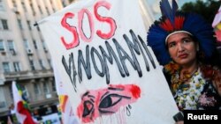Una mujer porta una pancarta pidiendo ayuda para el pueblo Yanomami durante una marcha por la democracia y los derechos indígenas en Porto Alegre, Brasil, el 25 de enero de 2023. 