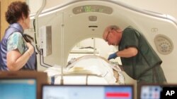 FILE - A physician uses a CT scanner to screen a patient for lung cancer at Southern New Hampshire Medical Center in Nashua, New Hampshire, June 3, 2010.