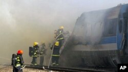 Israeli fire fighters spray water to extinguish the flames of a burning train coach near Kibbutz Shfaim, close to the Israeli city of Netanya about 15 kms (nine miles) north of Tel Aviv, after the passenger train caught fire on 28 Dec 2010