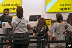 FILE - Penumpang antre di loket tiket Spirit Airlines di Bandara Internasional Tampa, di Tampa, Florida, 1 Juni 2023. (Chris O'Meara/AP)