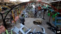 Warga setempat tengah memeriksa lokasi serangan bom bunuh diri di kota Sadr, 22 September 2013 (Foto: dok). Sedikitnya 21 orang dilaporkan tewas dalam dua pemboman di dua pasar yang ramai di Baghdad, Kamis (26/9).