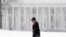 A pedestrian walks in the snow in Albany, New York. An early spring cold front is bringing snow and gusty winds to the Northeast after the region had one of its mildest winters on record.