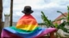 FILE - A gay Ugandan man covers himself with a pride flag as he poses for a photograph in Uganda Saturday, March 25, 2023. Uganda's LGBTQ community is concerned for their safety after the passing of a harsh new anti-gay bill.