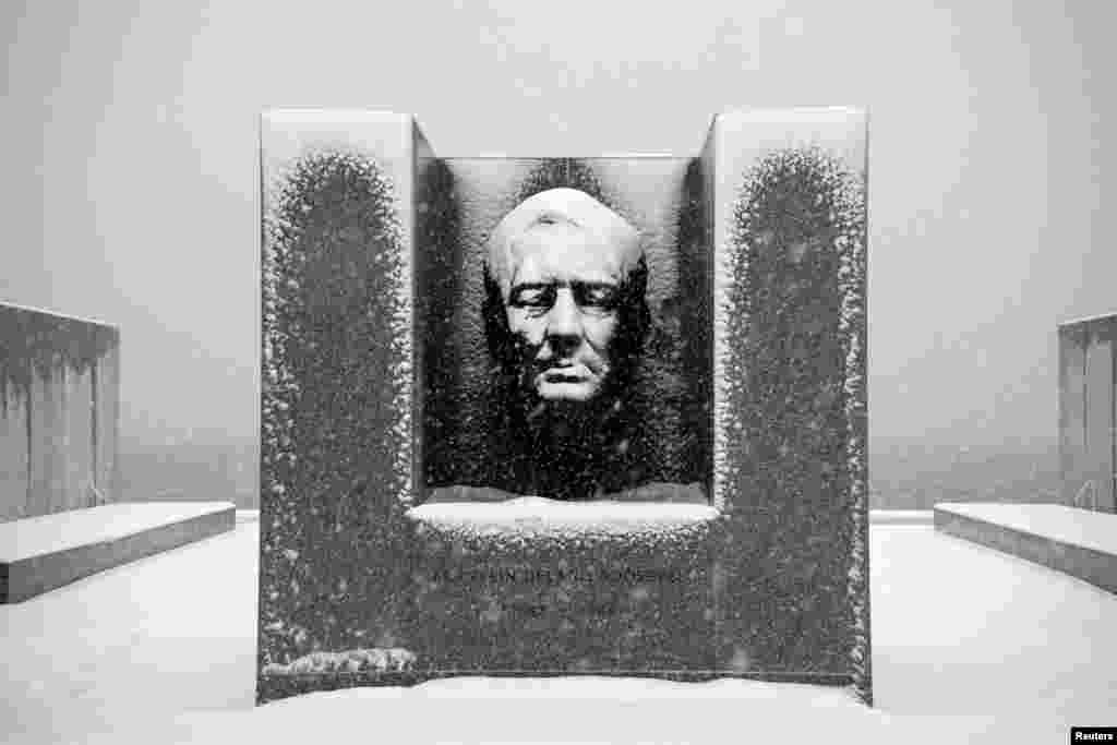 Snow falls on the statue of Franklin D. Roosevelt at Four Freedoms Park on Roosevelt Island in the borough of Manhattan in New York, Feb. 3, 2014.