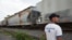 FILE - A migrant from Honduras stands by a passing train in Atitalaquia, on the outskirts of Mexico City June 26, 2014.