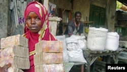 A moneychanger carrying Somali currency poses at an open air market in Mogadishu, Oct. 10, 2008.