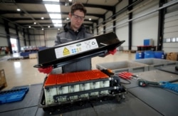 FILE - A used Lithium-ion car battery is opened before its dismantling by an employee of the German recycling firm Accurec in Krefeld, Germany, November 16, 2017. (REUTERS/Wolfgang Rattay/File Photo)