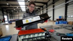 FILE - A used Lithium-ion car battery is opened before its dismantling by an employee of the German recycling firm Accurec in Krefeld, Germany, November 16, 2017. (REUTERS/Wolfgang Rattay/File Photo)