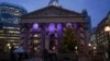 People walk past a Christmas tree outside the Stock Exchange in London, Dec. 4, 2024.