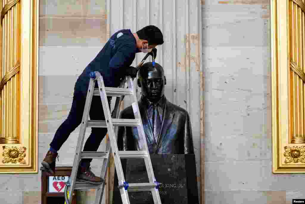 Gompo Yarmolinsky with the Architect of the Capitol cleans dust from the bust of Martin Luther King Jr. in the Capitol Rotunda after supporters of U.S. President Donald Trump stormed the U.S. Capitol in Washington.