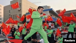 FILE - Chen Guangbiao, dressed in green respresenting is environmentalism, is seen at an event in Nanjing, Jiangsu province, Oct. 10, 2012.