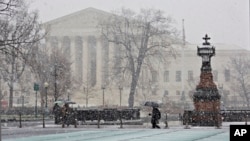 Snow and freezing rain fall on the Supreme Court and Capitol in Washington, prompting many agencies of the federal government to close for the wintry weather, Dec. 10, 2013.