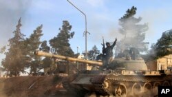 Un combattant des forces syriennes assis sur un tank dans la province de Raqqa, le 17 fevrier 2016.