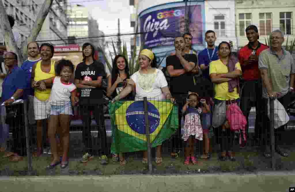 People waits for the Olympic torch on its way to Rio de Janeiro for the opening ceremony of Rio's 2016 Summer Olympics, in Niteroi, Brazil, Tuesday, Aug. 2, 2016. The three-month torch relay across Brazil will end at the opening ceremony on Aug. 5, in Maracana stadium. (AP Photo/Leo Correa)
