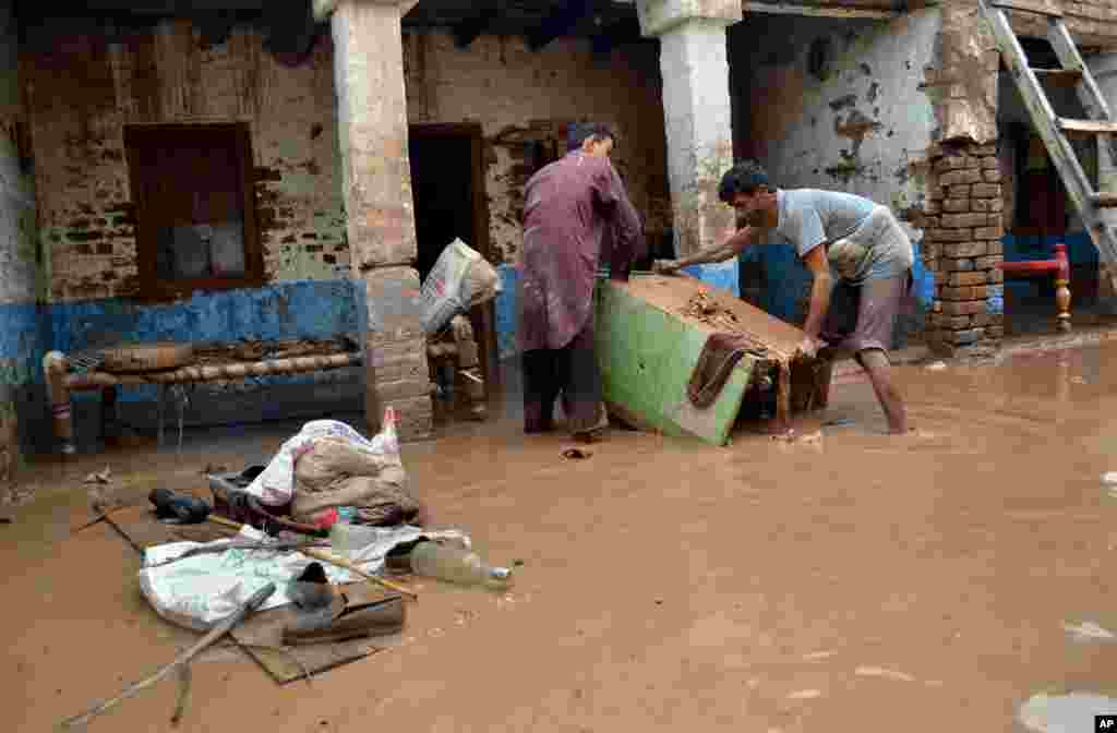 Pakistanis remove their belonging from a home flooded by heavy torrential rains in Peshawar, Pakistan, August&nbsp;3, 2013.&nbsp;