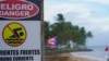 Un cartel de advertencia que dice "Peligro, no nadar" se ve en la playa de Luquillo, Puerto Rico, el 13 de agosto de 2024, mientras se acerca la tormenta tropical Ernesto.