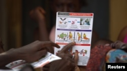 A UNICEF worker shares information on Ebola and best practices to help prevent its spread with residents of the Matam neighborhood of Conakry, Guinea in this handout photo courtesy of UNICEF taken Aug. 20, 2014. 