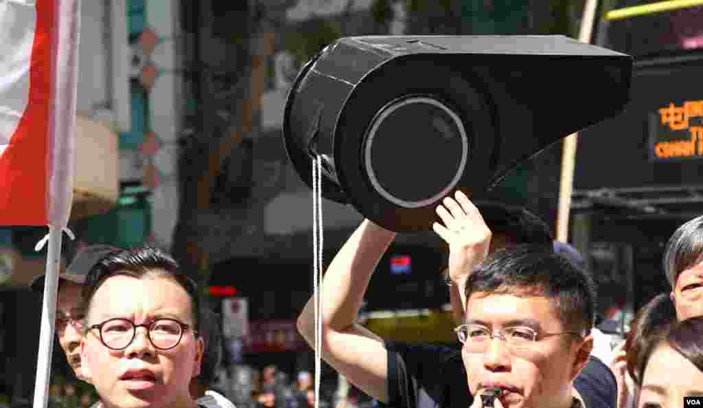 遊行人士高舉大型道具「黑哨」諷刺當局取締香港民族黨是「吹黑哨」。（美國之音湯惠芸拍攝）
