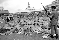 Dokumentasi foto 6 Oktober 1976, polisi berjaga-jaga atas mahasiswa sayap kiri Thailand di lapangan sepak bola di Universitas Thammasat, di Bangkok, Thailand. Bagi sebagian orang Thailand, peristiwa berdarah 6 Oktober 1976 masih merupakan mimpi buruk. (Foto: AP)
