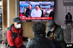 People watch a television news broadcast showing file footage of North Korean leader Kim Jong Un, at a railway station in Seoul on April 21, 2020.
