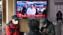 People watch a television news broadcast showing file footage of North Korean leader Kim Jong Un, at a railway station in Seoul on April 21, 2020.