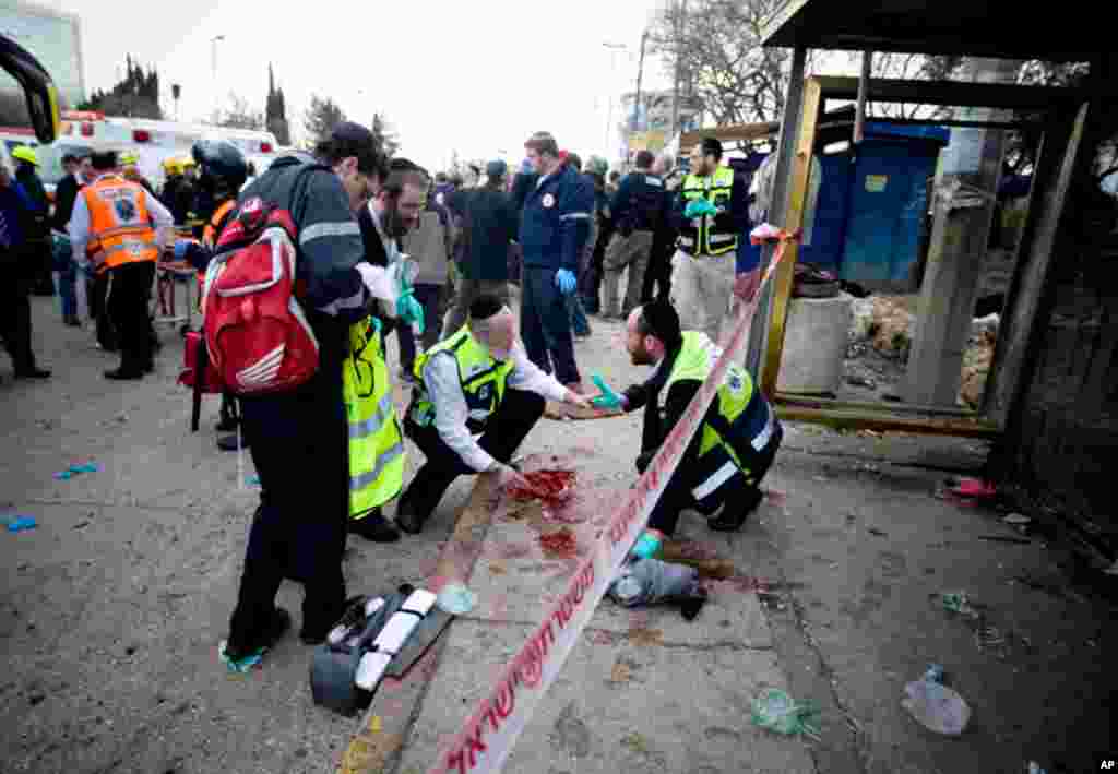 March 23: Israel Rescue workers and paramedics clean a pool of blood at a bus stop in Jerusalem after a bomb exploded, wounding dozens. It appeared to be the first militant attack in the city in several years. (AP/Ariel Schalit)
