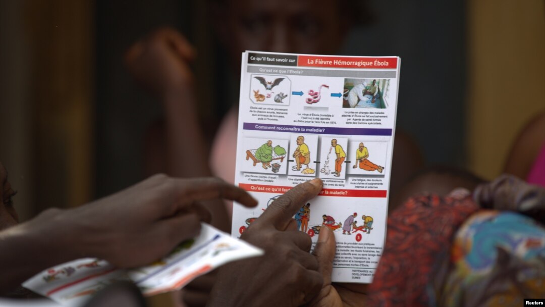 A UNICEF worker shares information on Ebola and best practices to help prevent its spread with residents of the Matam neighborhood of Conakry, Guinea in this handout photo courtesy of UNICEF taken Aug. 20, 2014. 