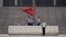 FILE - Policemen hoist a Chinese national flag at the entrance of a court in Jinan, where former disgraced politician Bo Xilai was held, September 22, 2013. 