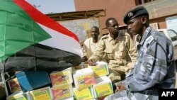 A Sudanese national flag is fixed by students heading to fight on the border with South Sudan on truck packed with relief aid at the University of Science and Technology in Khartoum, April 17, 2012.