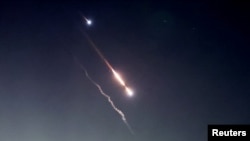 Objects are seen in the sky above Jerusalem after Iran launched drones and missiles towards Israel, in Jerusalem