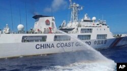 Sebuah kapal Penjaga Pantai China menembakkan meriam air ke arah kapal Penjaga Pantai Filipina di dekat Second Thomas Shoal yang diduduki Filipina, Laut China Selatan pada Sabtu, 5 Agustus 2023. (Foto: via AP )