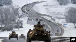 A convoy of Russian armored vehicles moves along a highway in Crimea, Jan. 18, 2022. Russia has concentrated an estimated 100,000 troops with tanks and other heavy weapons near Ukraine in what the West fears could be a prelude to an invasion.