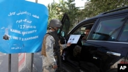 Afghan security personnel search a car at a checkpoint around the Green Zone, which houses embassies, in Kabul, May 25, 2021. Australia is shutting its embassy this week, citing security concerns ahead of the final withdrawal of U.S. and NATO troops.