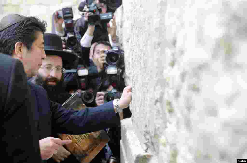 Japan&#39;s Prime Minister Shinzo Abe touches the Western Wall during a visit to the Old City of Jerusalem.