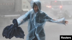A woman runs in the rainstorm as Typhoon Mangkhut approaches, in Shenzhen, China, Sept. 16, 2018. 