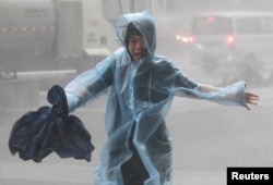 A woman runs in the rainstorm as Typhoon Mangkhut approaches, in Shenzhen, China, Sept. 16, 2018.