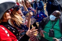 A Biden supporter who would only give his first name, Douglas, right, debates with Trump supporters demonstrating against the election results outside the central counting board at the TCF Center in Detroit, Nov. 6, 2020.