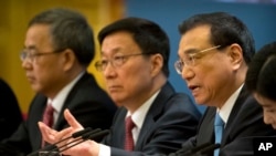 Chinese Premier Li Keqiang (R) is flanked by Vice Premiers Hu Chunhua (L) and Han Zheng during a press conference in Beijing, March 20, 2018. The premiere appealed to Washington to 'act rationally' and avoid disrupting trade. 