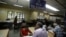 An Indian woman, foreground left, waits to send a telegram at Bharat Sanchar Nigam Limited (BSNL), a state-run telecom company in Bangalore, India, June 14, 2013.