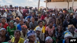 FILE - People displaced by conflict listen to a speech by the UN delegation in Komanda, Ituri province, eastern Democratic Republic of Congo, Aug. 30, 2023.