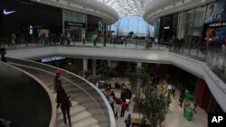 FILE - Shoppers make their way along the wide avenues inside the newly opened Mall of Africa in Midrand, South Africa, April 28, 2016.