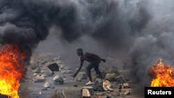 FILE - A protester sets up a barricade during a protest against Burundi President Pierre Nkurunziza and his bid for a third term in Bujumbura, Burundi, May 22, 2015. 