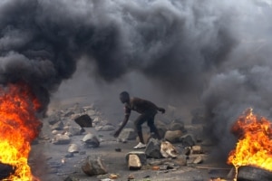 FILE - A protester sets up a barricade during a protest against Burundi President Pierre Nkurunziza and his bid for a third term in Bujumbura, Burundi, May 22, 2015.