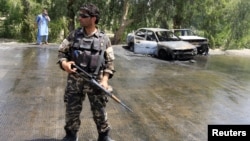 An Afghan security force stands guard at the site of a suicide attack in Jalalabad city, Afghanistan July 10, 2018. 