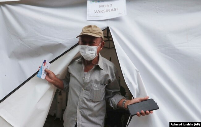 Erri Suprijadi berusia 70 tahun meninggalkan tenda setelah menerima suntikan vaksin COVID-19 di sebuah puskesmas di Jakarta, 8 Februari 2021. (Foto: Achmad Ibrahim/AP)