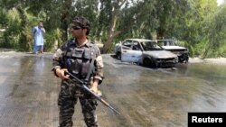 Pripadnik avganistanskih bezbednosnih snaga stražari na mestu napada u Jalalabadu, Avganistan, 10. jula 2018.