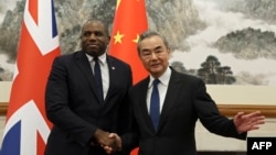 British Foreign Secretary David Lammy, left, and Chinese Foreign Minister Wang Yi shake hands before their meeting at the Diaoyutai State Guesthouse in Beijing on Oct. 18, 2024.